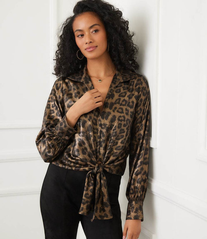 Woman wearing shimmer animal print long sleeve tie-front top with collared neckline and buttoned cuffs
