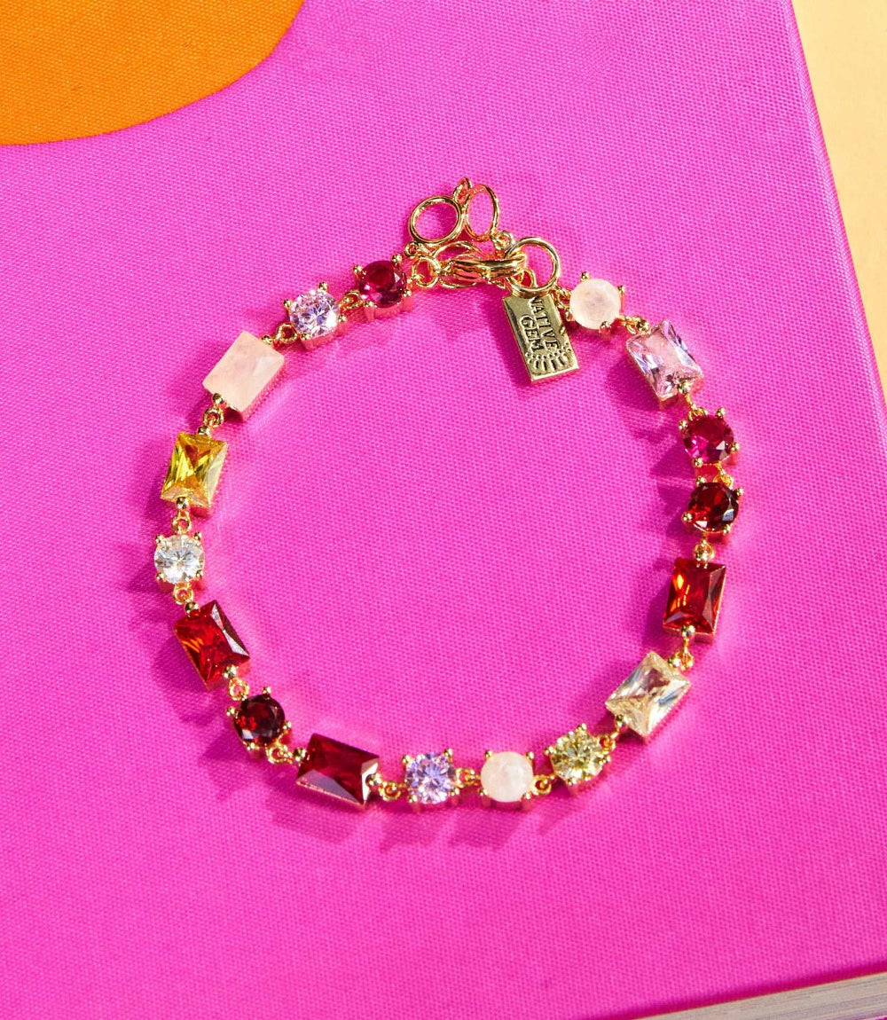 Calypso Crystal Bracelet with red, pink, multi-colored cubic zirconia and rainbow moonstone set in 4K gold vermeil on pink background