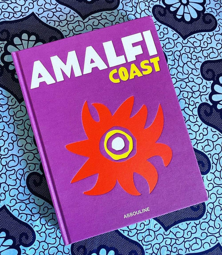 Hardcover Amalfi Coast coffee table book with vibrant purple cover and red floral design by Carlos Souza