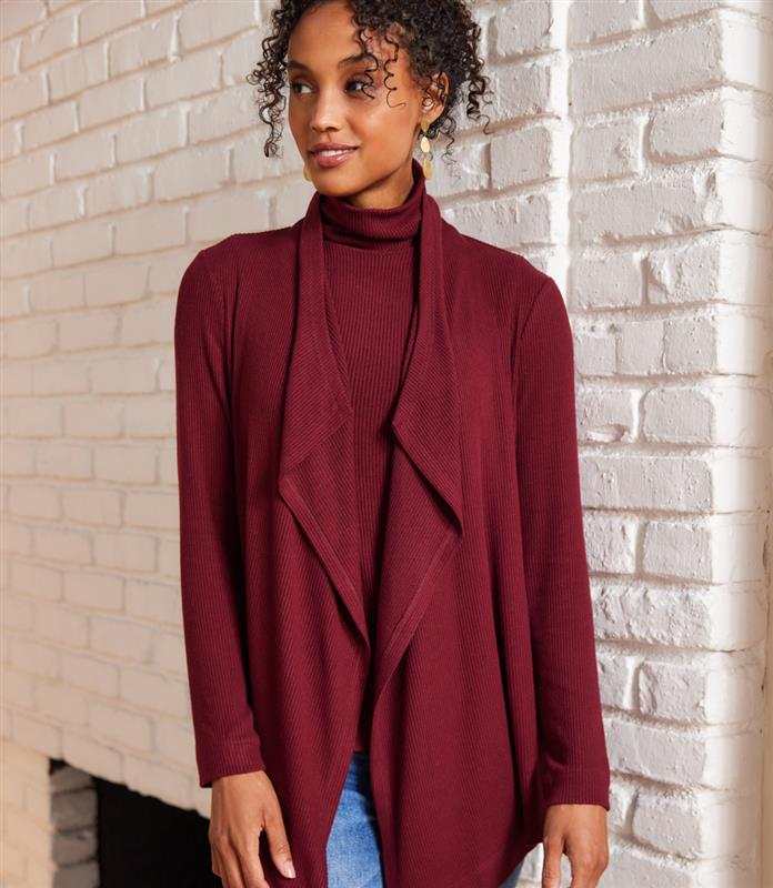Woman wearing burgundy long sleeve ribbed drape front cardigan with open neckline and high-low hem