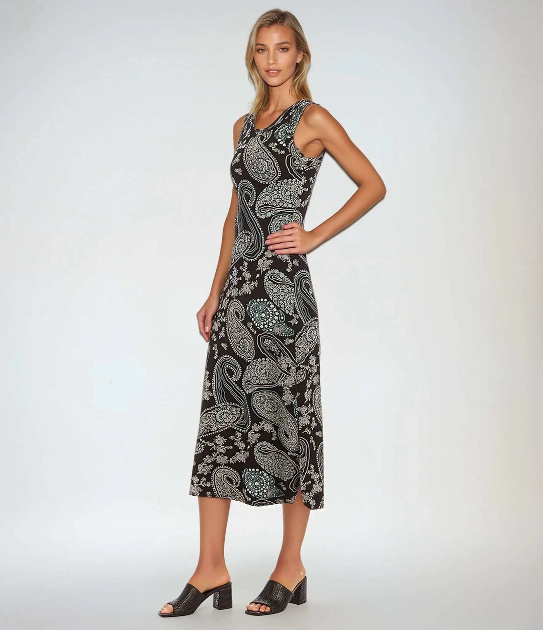 Woman wearing sleeveless midi dress with aqua paisley print on black background