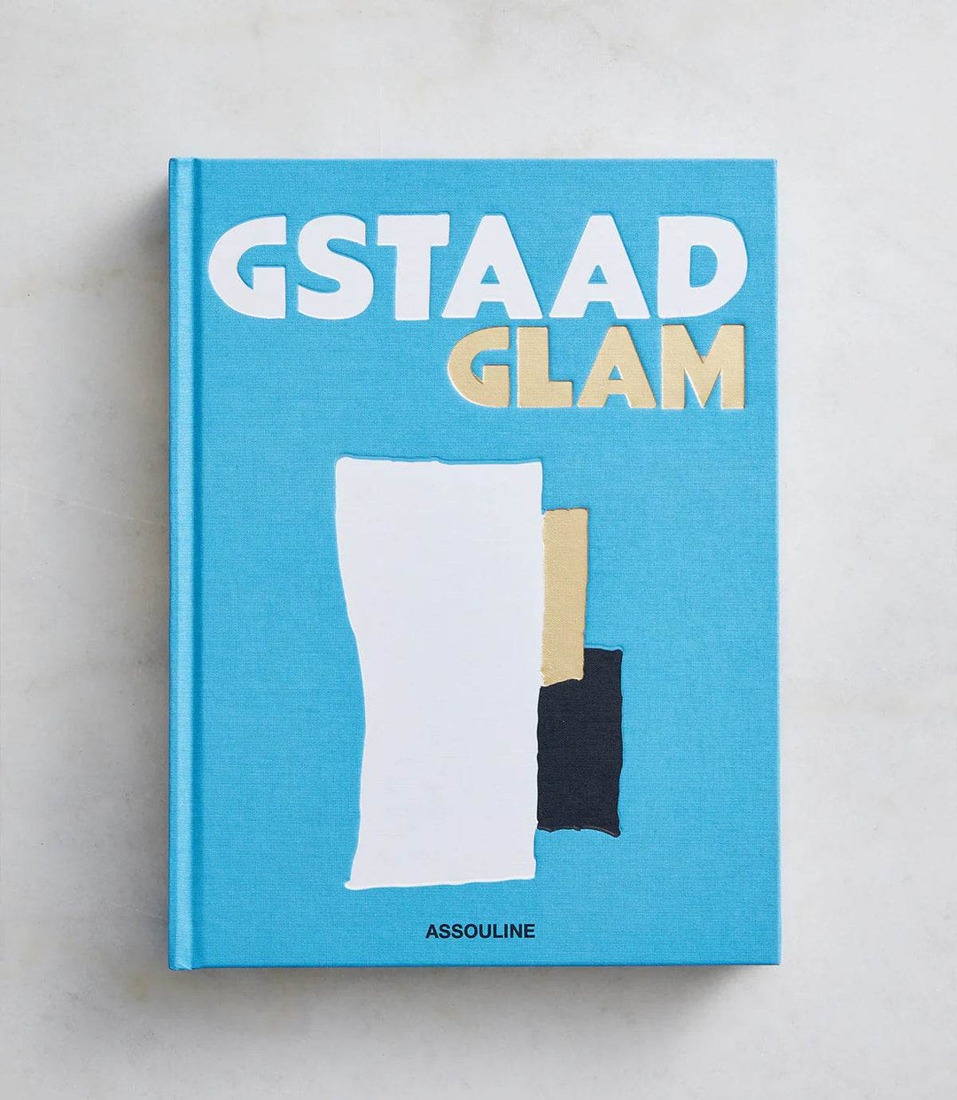 Cover of the hardcover book "Gstaad Glam" in blue with abstract shapes and bold white and gold text.