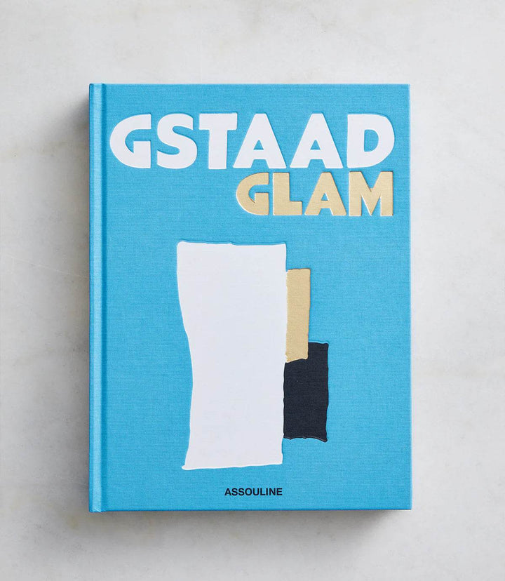 Cover of the hardcover book "Gstaad Glam" in blue with abstract shapes and bold white and gold text.