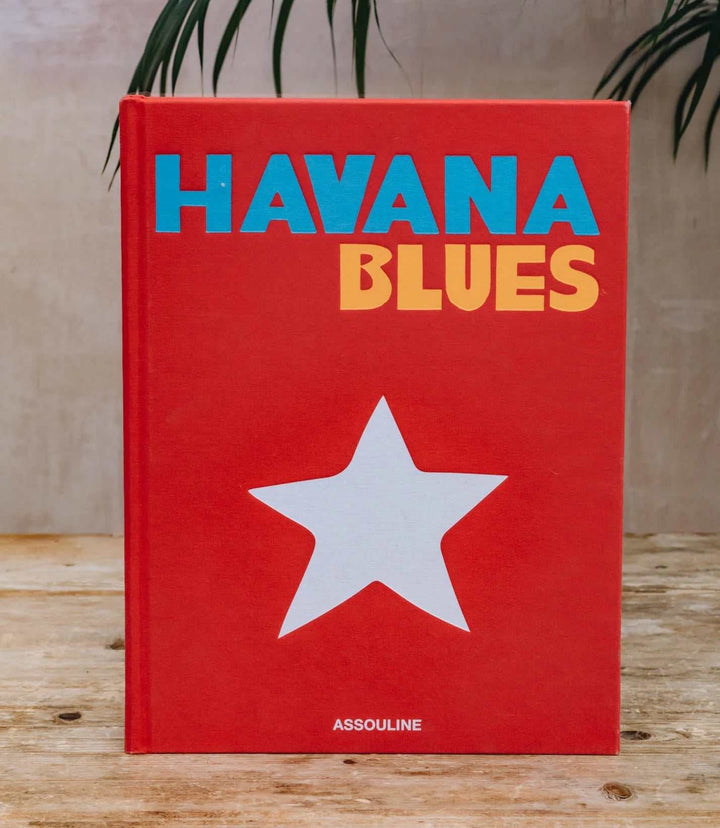 Havana Blues hardcover book with red cover, blue and yellow title, and white star on wooden table