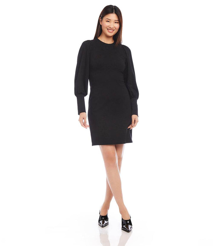 Petite size black bishop sleeve dress with wide cuffs and crew neck on model