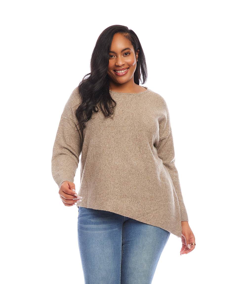 Plus size asymmetric sweater in soft beige with crew neck and drop shoulder sleeves modeled by smiling woman