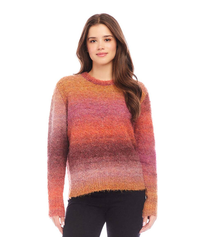 Woman wearing an ombre boucle sweater with a soft, loose fit and crew neck in shades of orange, pink, and purple.