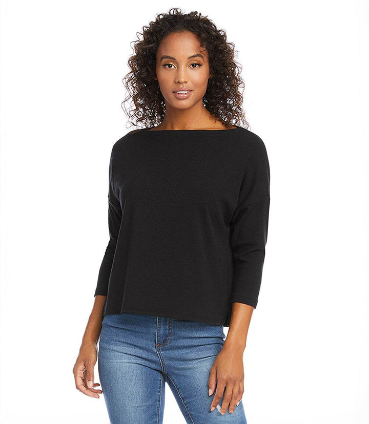 Woman wearing a black boatneck top with 3/4 length sleeves and blue jeans