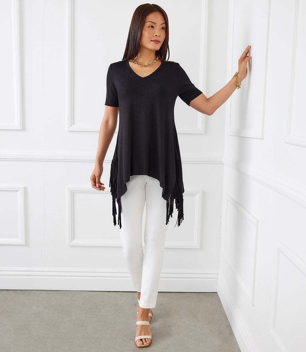 Petite size short sleeve black fringe top with V-neck and hi-lo hem worn with white pants
