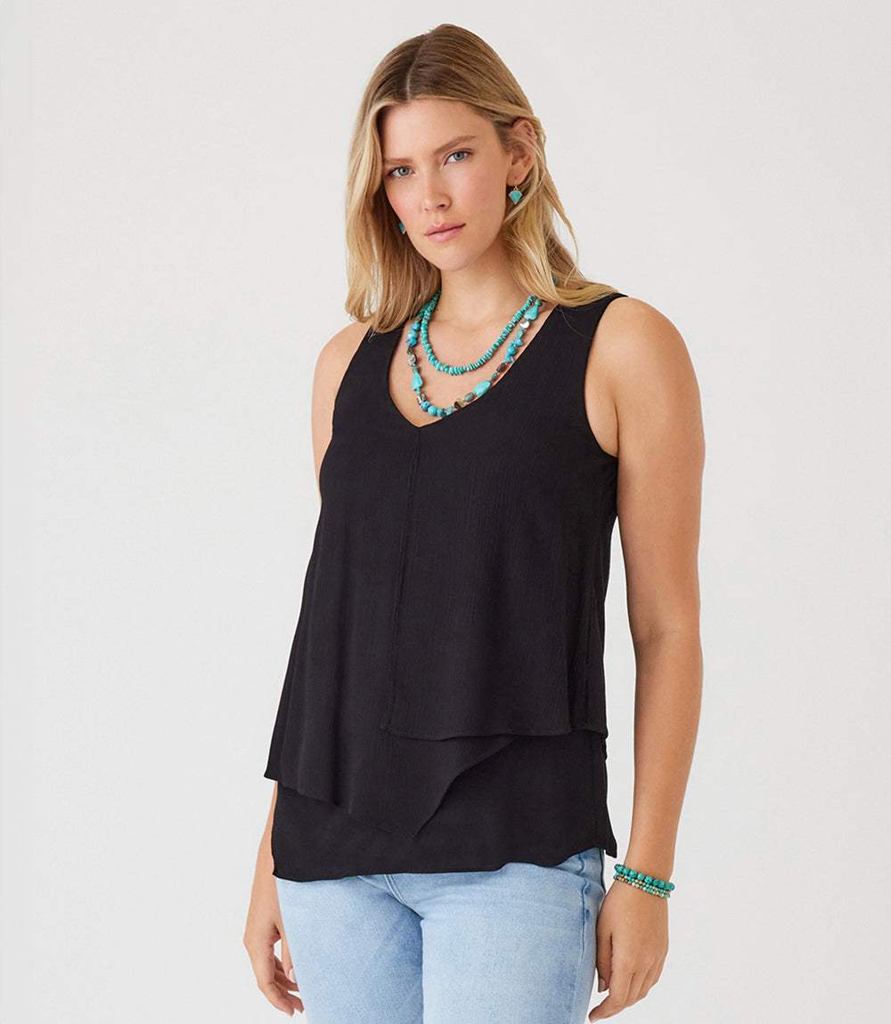 Black layered tank top with asymmetric hem and V-neckline worn with turquoise jewelry and light blue jeans