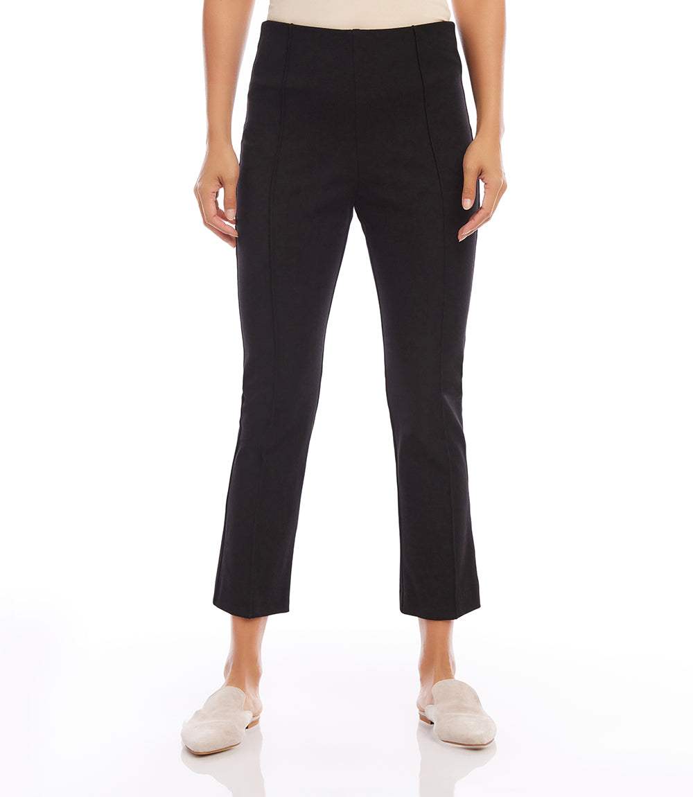 Cropped pintuck pants in black with elastic waistband and tailored fit, styled with slip-on shoes.