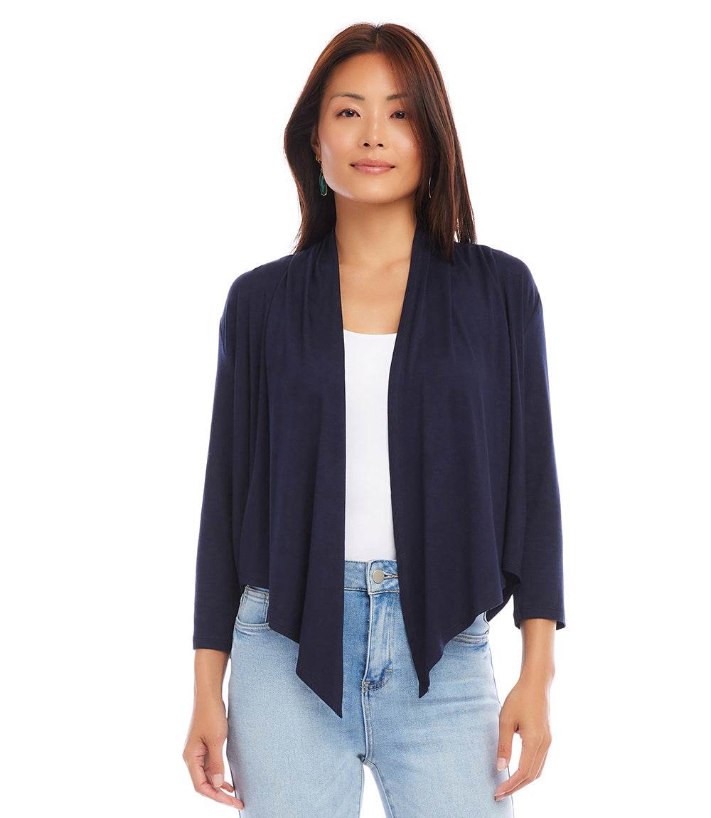 Woman wearing navy blue Calli Cardigan with draped front and 3/4 sleeves over white top and light blue jeans
