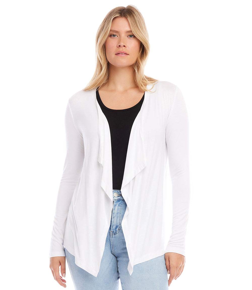 Woman wearing white Poppy Cardigan with draped front and long sleeves over black top and blue jeans