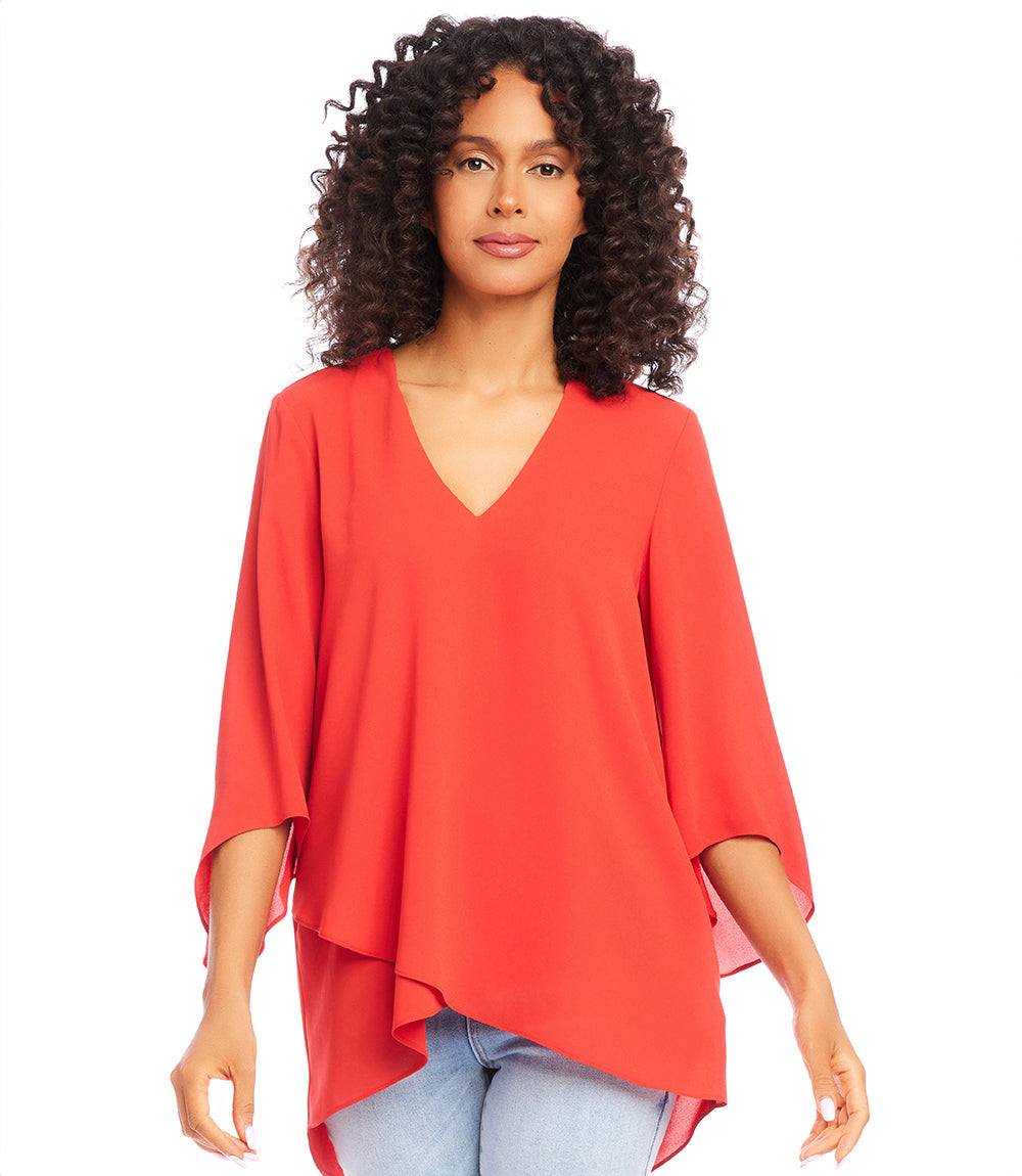 Woman wearing a red bracelet sleeve asymmetric top with V-neck and layered hem