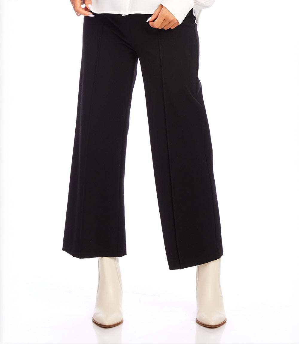 Black pintuck wide leg pants with cropped ankle length and elastic waist paired with white boots.