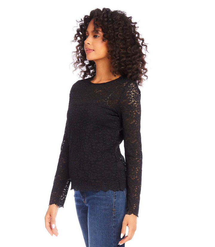 Woman wearing black scalloped lace top with sheer long sleeves and crew neck paired with blue jeans