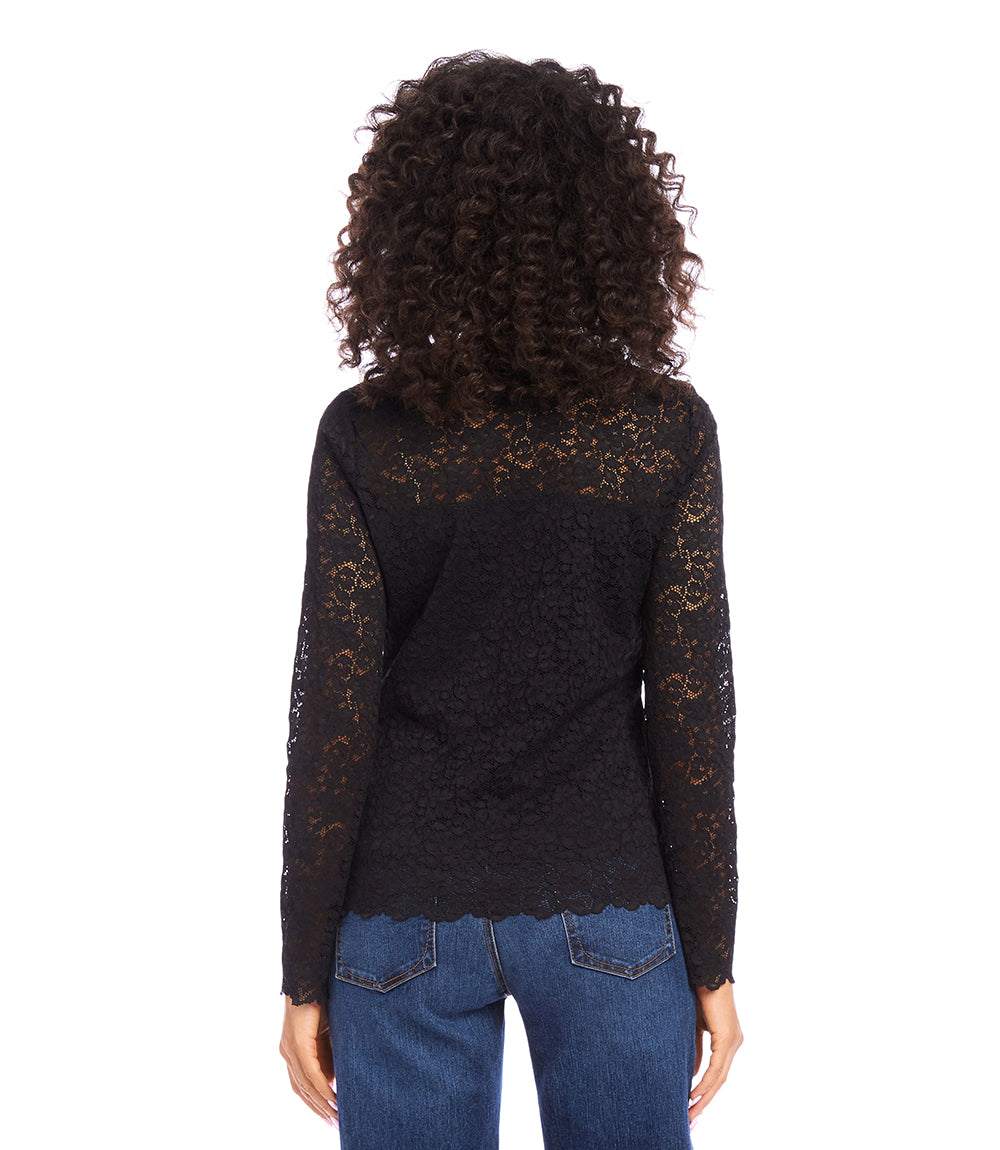 Woman wearing black scalloped lace top with sheer long sleeves and crew neck seen from back