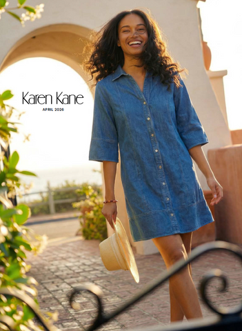 Woman wearing a blue dress with a sun hat, standing outdoors with 'Karen Kane' branding.