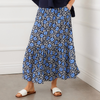 Person wearing a blue floral skirt with a white background
