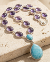 Necklace with purple and turquoise stones on a textured surface