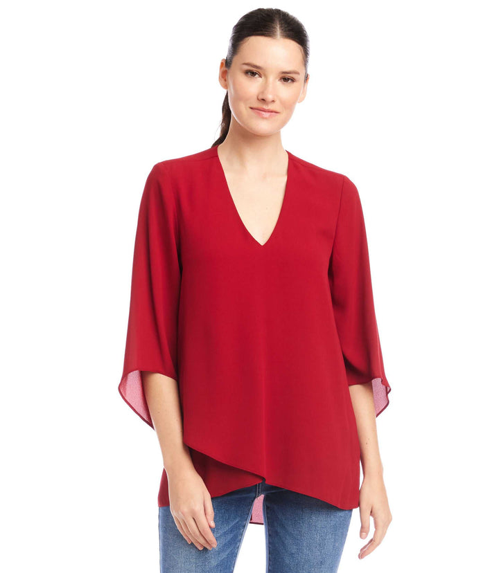 Woman wearing a red Bracelet Sleeve Asymmetric Top with V-neck and layered hem.