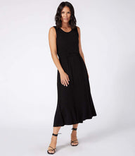 Woman wearing a black sleeveless artisan dress with elastic waistband and side pockets