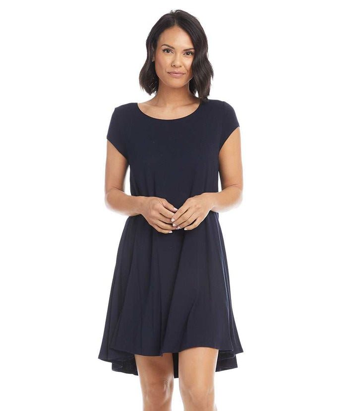 Woman wearing a navy Maggie Trapeze Dress with cap sleeves, boat neckline, and high-low hem made from stretch-jersey knit.