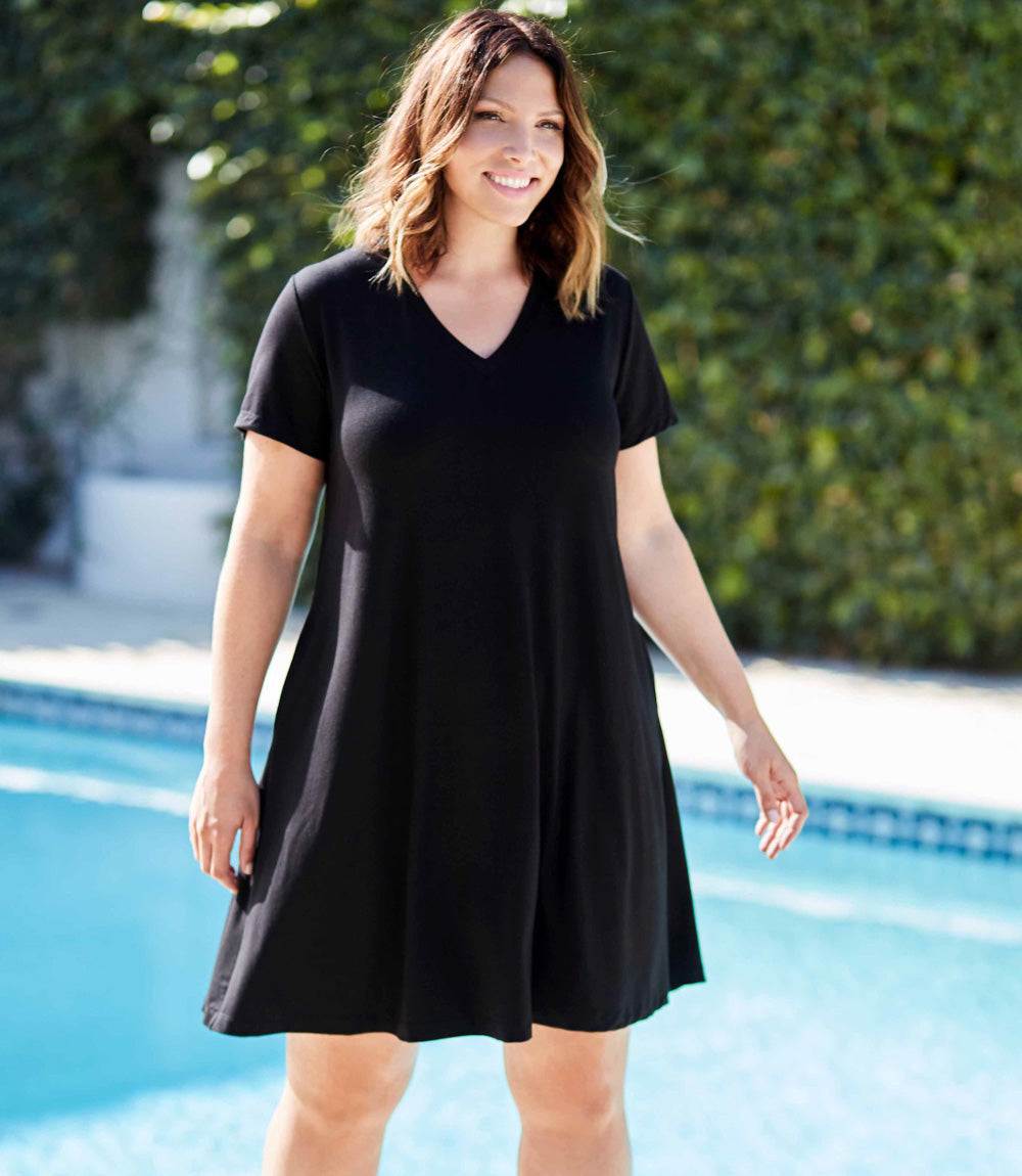 Plus Size Quinn V-neck black pocket dress with short sleeves and relaxed fit modeled outdoors near a pool
