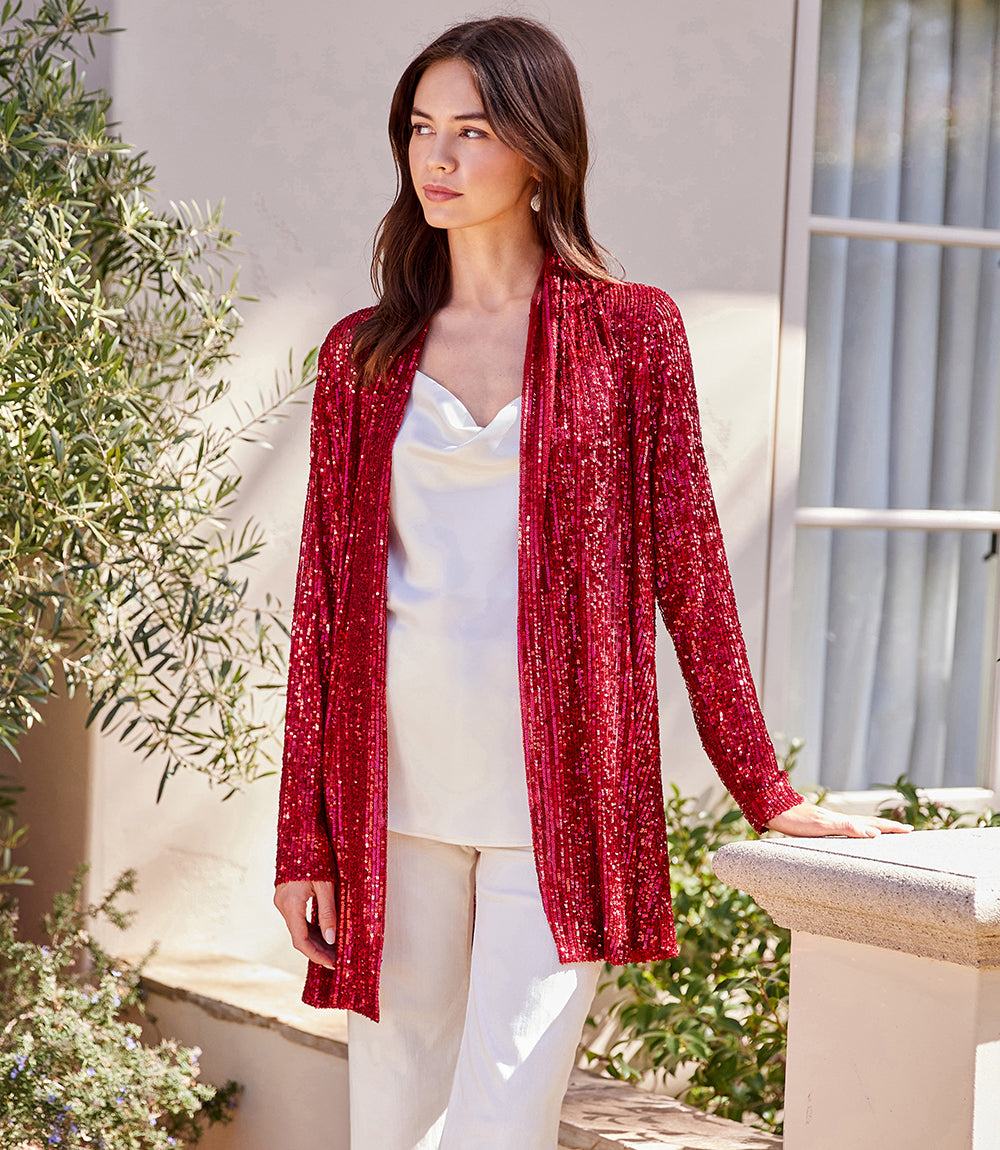 Women wearing red sequin duster with long sleeves and open front over white top and pants